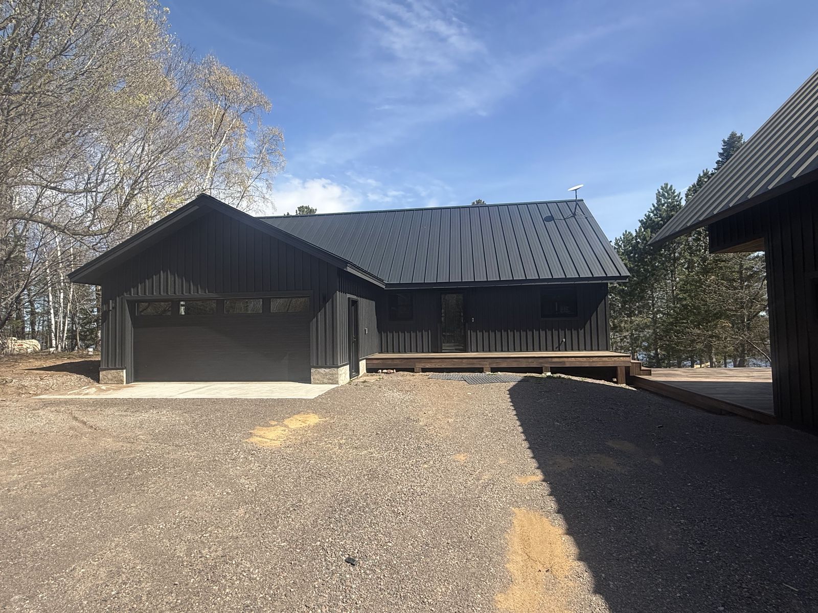 Attached garage wing of the Island Lake custom home with matching dark siding