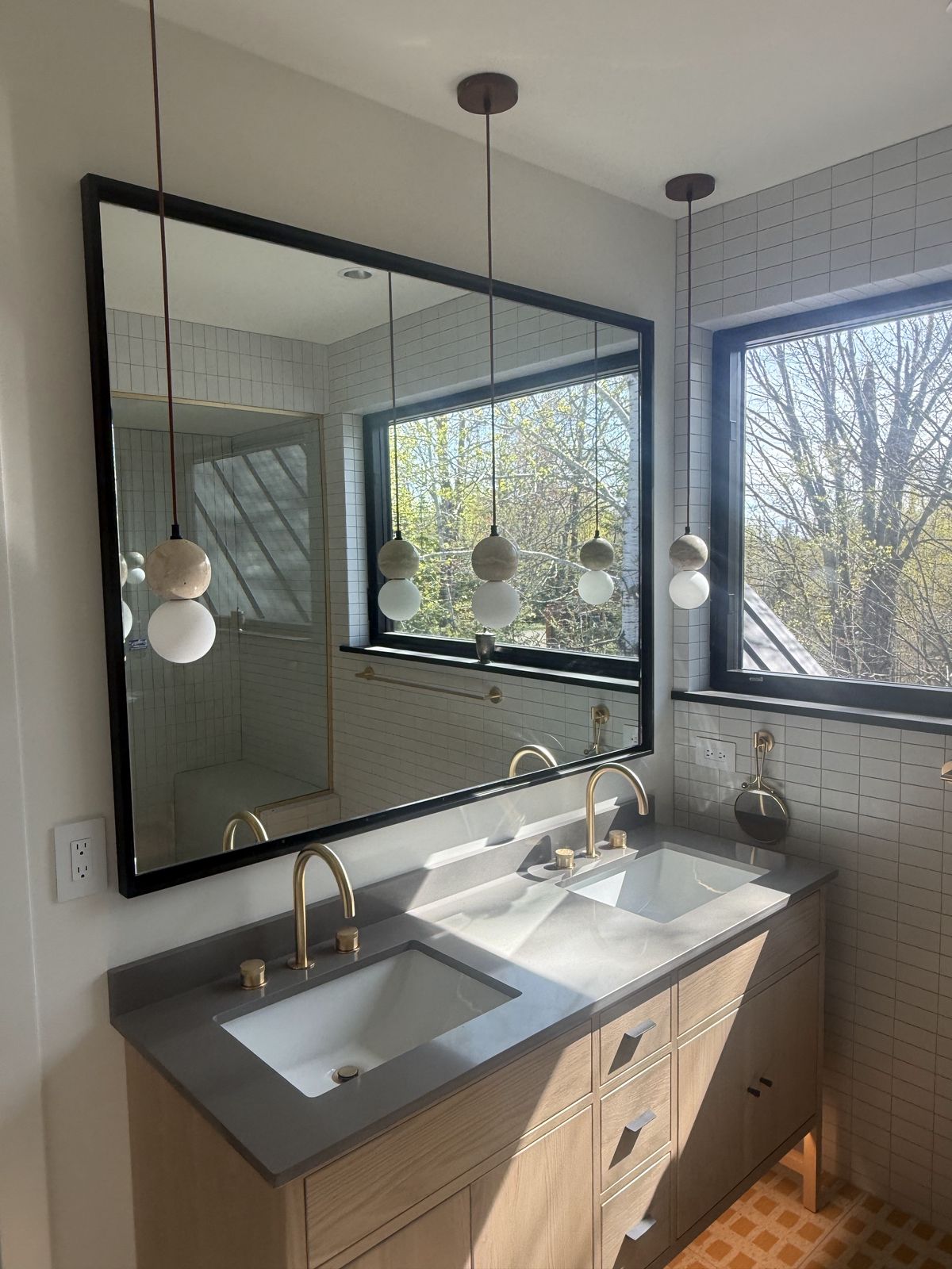Bathroom with a floating wood vanity and mirror in the Island Lake custom home