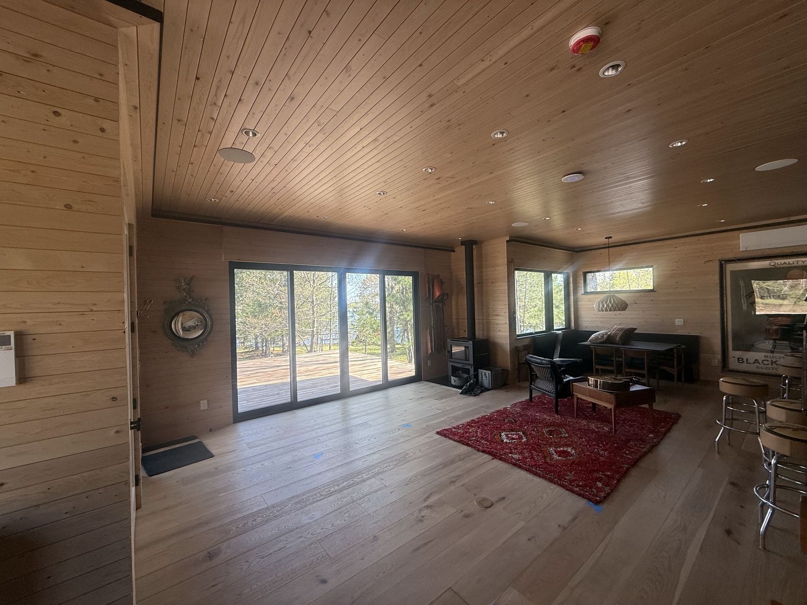 Living room with a wood ceiling and large windows framing the lake view